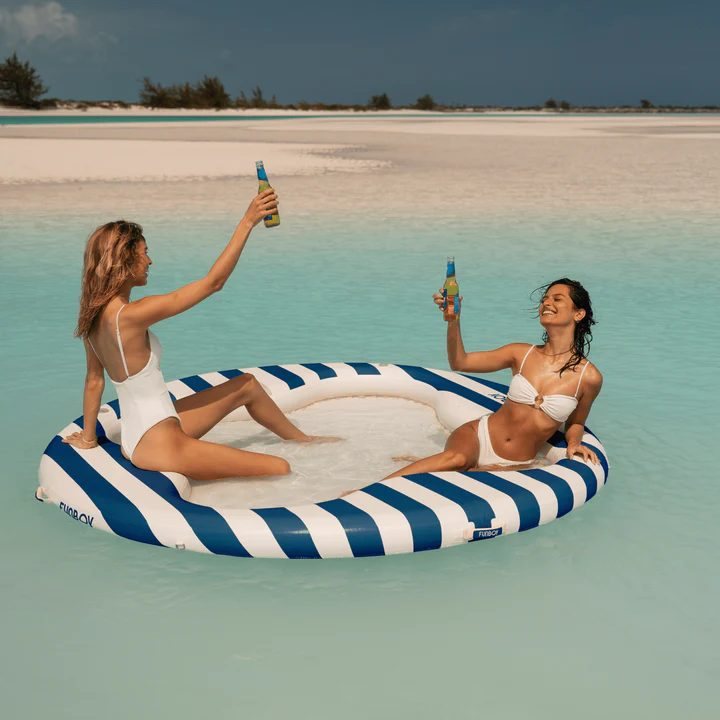 Deux amies sur une bouée rayée en mer